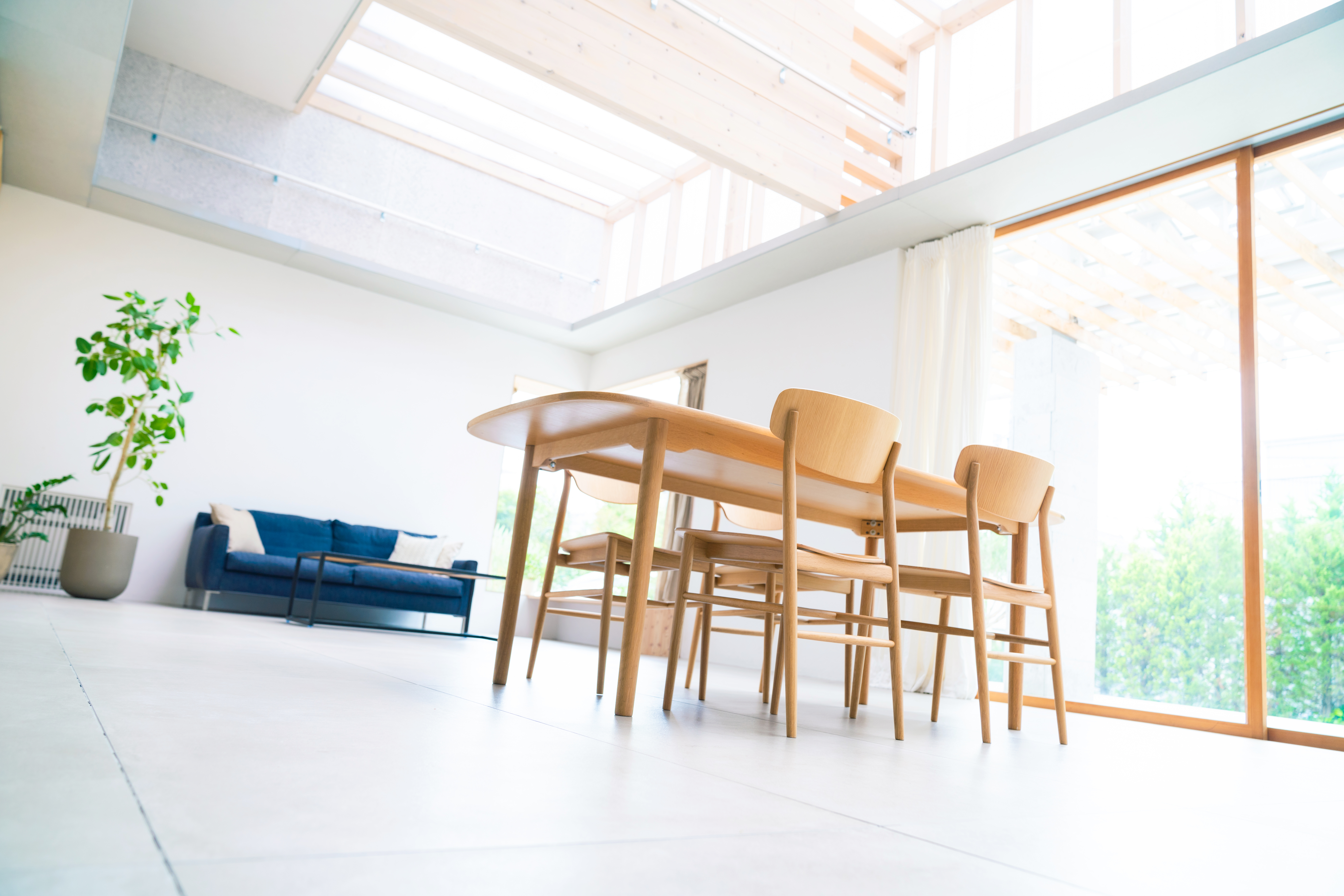 A 3D model of a room with a table, chairs, and a couch, shown from a low angle looking up. 