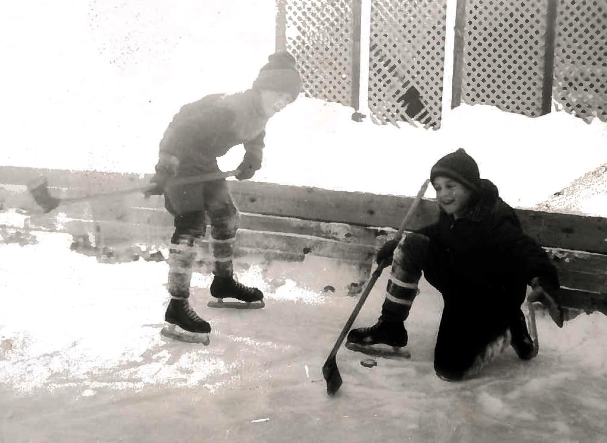 Young children play ice hockey